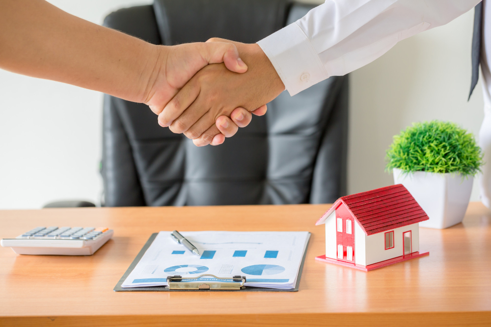 two people shaking hands after a deal on house sale